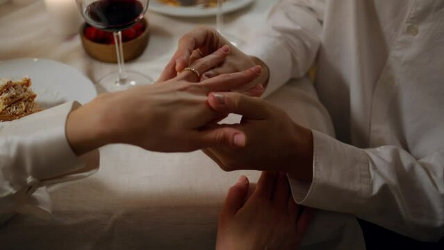 Man hands wearing engagement ring romantic dinner close up. Two lovers proposal