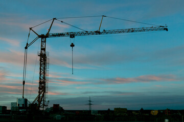 Fototapeta na wymiar black crane silhouette against blue sky at sundown