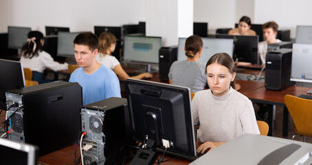 Teenage caucasian girl learning to use personal computer during lesson in school.