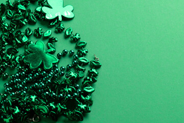 Image of green clover and jewellery and copy space on green background