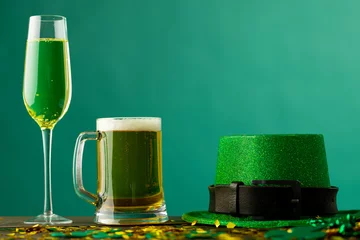 Fotobehang Image of beer and champagne glasses, green hat and copy space on green background © vectorfusionart