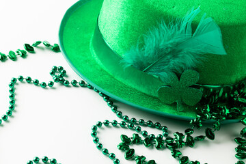 Image of green hat, green clover, green necklace and copy space on white background