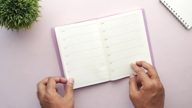 turning pages of a weekly planner