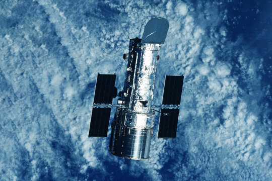 Space telescope above the surface of the planet. Elements of this image furnished by NASA