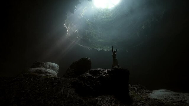 Woman With Arms Raised Standing On Rock In Jomblang Cave - Java, Indonesia