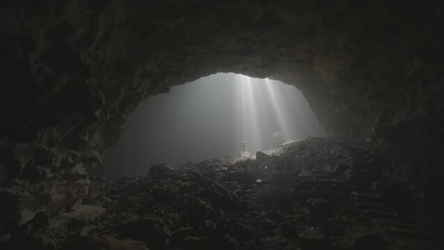 Woman Posing In Sunrays Passing In Sinkhole Cave During Vacation - Java, Indonesia