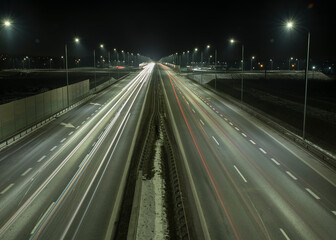 widok świateł pędzących oświetloną autostradą aut nocą - obrazy, fototapety, plakaty