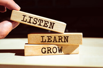 Wooden blocks with words 'Listen, learn, grow'.