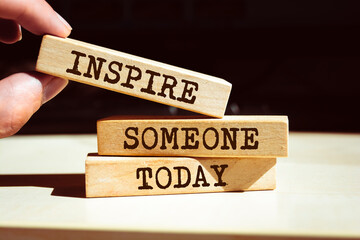 Wooden blocks with words 'Inspire someone today'.