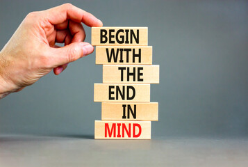 Begin in end of mind symbol. Concept words Begin with the end in mind on wooden blocks. Beautiful grey table grey background. Businessman hand. Business begin in end of mind concept. Copy space.