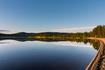 Fototapeta premium Peaceful landscape of Lake Inari with the midnight sun in Lapland, Finland