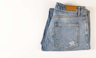 Blue jeans lie on a white background, denim texture.