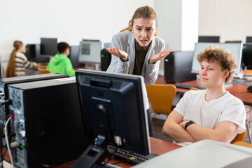 Frustrated worried young female teacher emotionally talking to neglectful teenage student sitting...