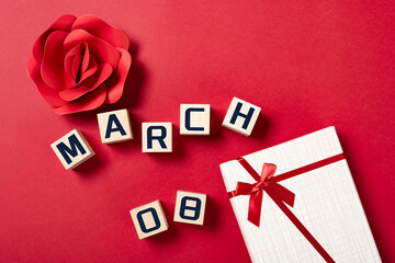 MARCH 08 and flower and gift box on red horizontal composition concept for international womens day