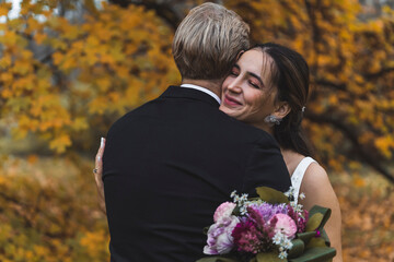 Beautiful Young Multiethnic couple embracing in a park during autumn. High quality photo