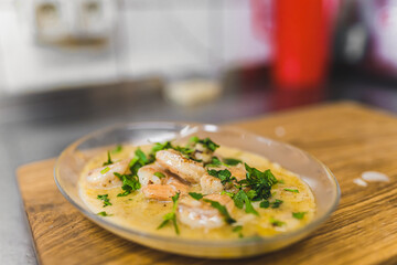 Shrimps in spicy chilli sauce on transparent platter ready for serving. Restaurant kitchen food plating process. Horizontal indoor shot. High quality photo