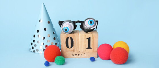 Calendar and party decor for April Fools' Day on light blue background