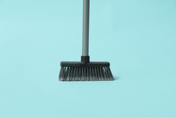 Plastic sweeping broom on color background