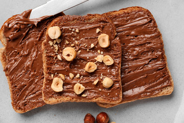 Plate of tasty toasts with hazelnut butter and nuts, closeup