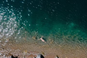 Traveler woman swimming in Lake Atitlan - young woman enjoying summer in Lake Atitlan Guatemala drone view