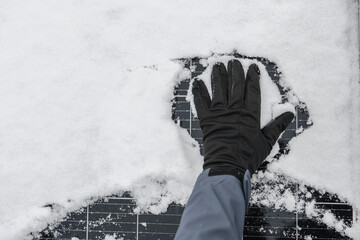 renewable energy in winter time. Getting electricity with solar panels in winter.Hands in black...