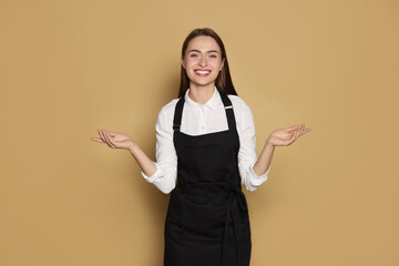 Portrait of happy hairdresser on beige background