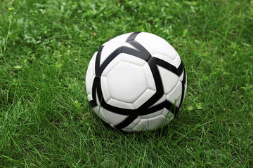 Fototapeta na wymiar New soccer ball on fresh green grass outdoors