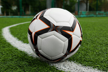 Fototapeta na wymiar New soccer ball on green football field