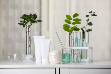 Fototapeta na wymiar Many containers and glass tubes with leaves on white lab drawer indoors