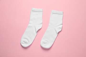 Pair of white socks on pink background, flat lay
