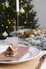 Beautiful festive place setting with blank card and stylish decor for Christmas dinner on white table. Space for text