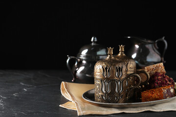 Tea and Turkish delight served in vintage tea set on dark grey textured table, space for text