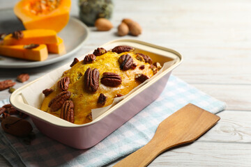 Delicious pumpkin bread with pecan nuts on light wooden table. Space for text