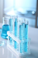 Test tubes with light blue liquid in laboratory, closeup