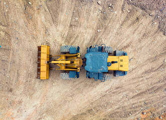 Fototapeta na wymiar bulldozer on earthmoving at construction site, aerial view.