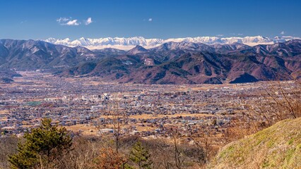 長野県・上田市 高台から眺める市街地と冬の北アルプスの風景