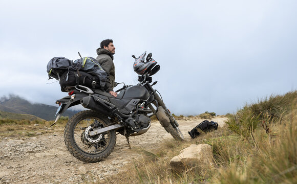 Motorcyclist man stands with the adventure motorcycle.Motorbike on the top of the mountain. Motorcycle trip. off road.