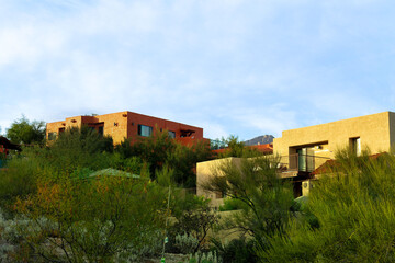 Adobe style buildings with flat roofs and stucco exteriors with desert pallets and colors with back...