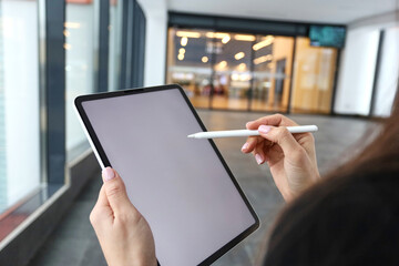Financial analyst buys shares in the investment market close-up. Working business man on background check. Working business woman on background check. A woman uses a tablet .