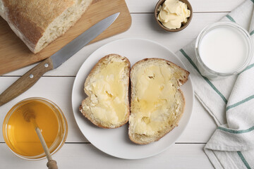 Flat lay composition of sandwiches with butter, honey and milk on white wooden table