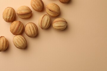 Homemade walnut shaped cookies with condensed milk on beige background, flat lay. Space for text