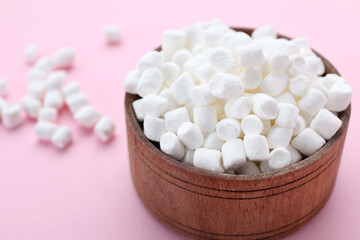 Fototapeta na wymiar Bowl with delicious marshmallows on pale pink background, closeup