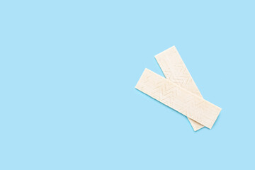 Sticks of tasty chewing gum on light blue background, flat lay. Space for text