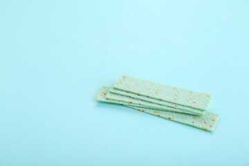 Many sticks of tasty chewing gum on light blue background. Space for text