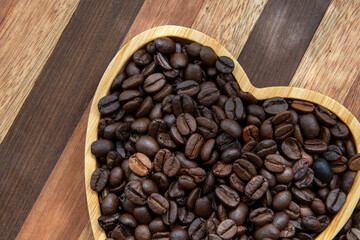 Fototapeta premium coffee beans in heart-shaped tra,y representing love of coffee