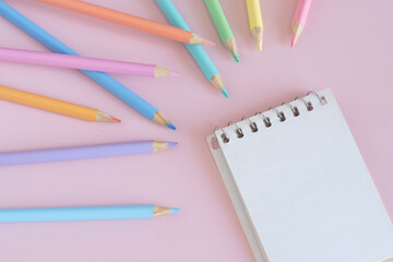 Pastel colored pencils, top view on pink background, illustration concept, education and back to school