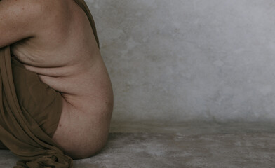 Fototapeta premium side profile of non-binary person showing skin texture and body rolls