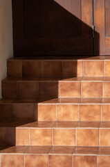 Burnt Sienna Tile Staircase in Sunlight with a Shadow.