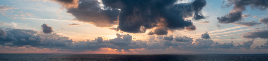 Dramatic Colorful Sunset Sky over Mediterranean Sea. Clouds with Sunrays. Cloudscape Nature Background. Panorama
