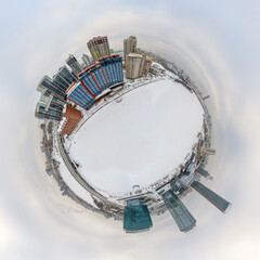 Aerial winter city view with crossroads and roads, houses, buildings, parks and bridges. Copter shot. Little planet sphere mode.